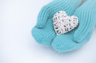 Female hands in mittens with heart, close-up