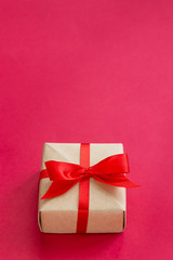 brown gift box with red ribbon on red background top view for christmas or celebrate