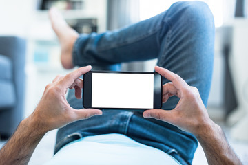 Mockup of a Man Using Smartphone Lying on a Floor at Home. Clipping path included.