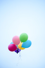 Multi colored balloons flying up in the sky