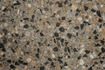 Gros plan texture béton désactivé avec graviers gris, noir et couleur