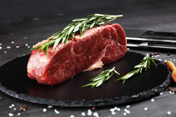 Steak raw. Barbecue Rib Eye Steak or rump steak on dark rustic table
