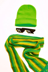 Stylish clothes. Bright green cap, pixel glasses, and a striped scarf. Minimal style. autumn and...