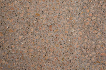 Gros plan texture béton désactivé avec graviers gris, noir et couleur rose