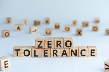 Zero tolerance - words from wooden blocks with letters, severely punishing all unacceptable behaviour, zero tolerance concept, random letters around, white  background
