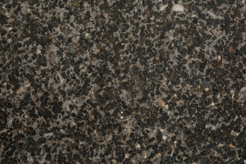 Gros plan texture béton désactivé avec graviers gris, noir et couleur