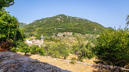 Fototapeta na wymiar Beautiful landscape with church and mountain in background, Valldemossa, Mallorca, Spain