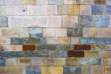 A neatly folded wall of stone blocks of different sizes and shades of color.