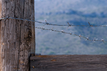 Wooden fence with barbed wire