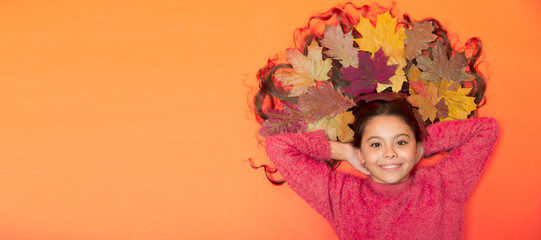 Im hairdresser. Happy girl with colorful leaves in hair. Small child in autumn mood on brown background. Hair salon. Hairdressers salon or parlor. Kids barber. Beauty salon. Hairdressing, copy space