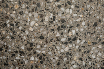 Gros plan texture béton désactivé avec graviers gris, noir et couleur