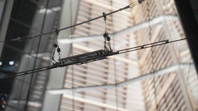 Train support guide wires set against modern architecture.  