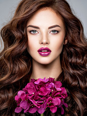 Fototapeta na wymiar Stunning woman with long hair and bright violet make-up.