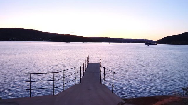 Diving platform overlooking a vast body of water at sunset