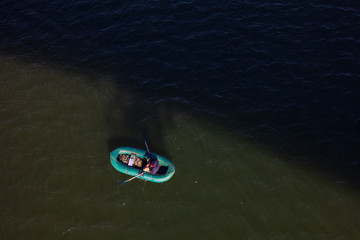 Obraz premium A Fisherman In A Boat Floating On The River