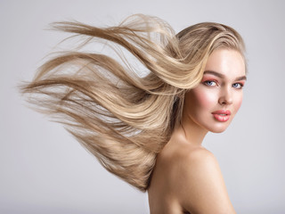 Portrait of a blonde beautiful woman with a long straight light hair. Flying hair.