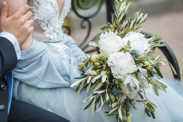 wedding bouquet in hands of bride and groom