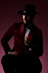 young fashion model wearing red velvet tuxedo and hat