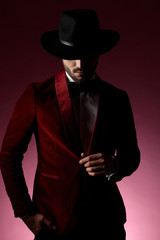 mysterious young man wearing red velvet tuxedo and hat