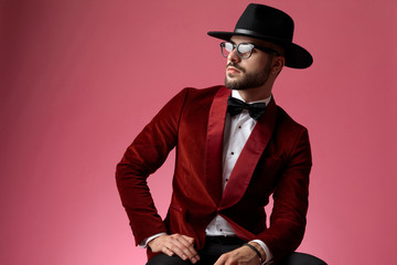 young fashion man wearing red velvet tuxedo and looking to side