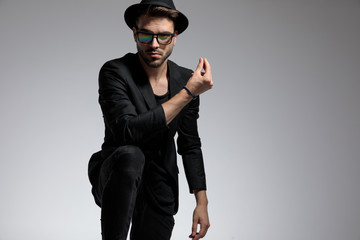 casual man standing with one leg up snapping his fingers