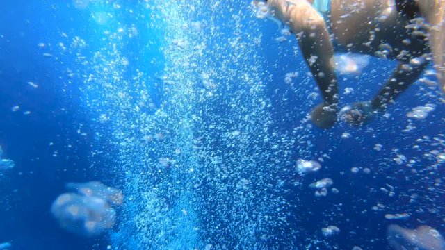 Beautiful girl trying to catch bubbles underwater
