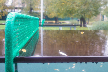 Wet ping pong table with reflection in the rain in the Park on a cloudy autumn day