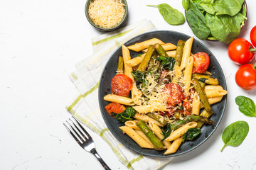 Vegan pasta penne with spinach, asparagus and tomato.