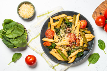 Vegan pasta penne with spinach, asparagus and tomato.