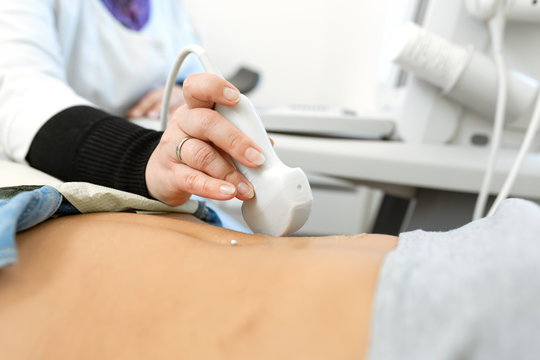 Close-up doctor conducts ultrasound diagnostics of the patients abdomen and internal organs