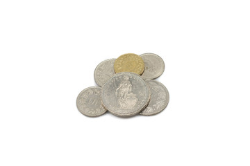 A close up image of a pile of silver and gold Swiss franc coins isolated on a clean, white background.  Shot in macro.