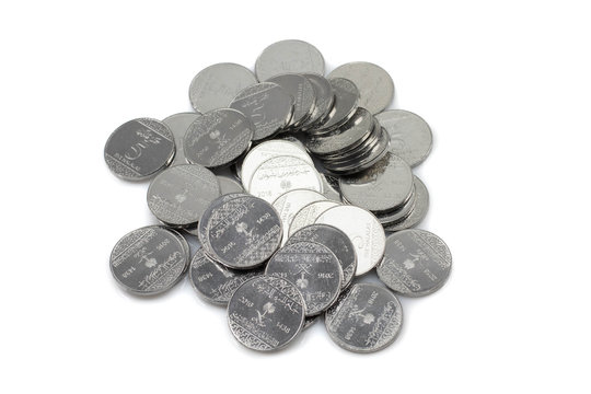 A close up image of a pile of Saudi Arabian five halala coins isolated on a white background.  Shot in macro