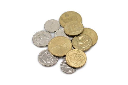 A close up, macro image of a pile of silver and gold coins from Israel shot against a white background