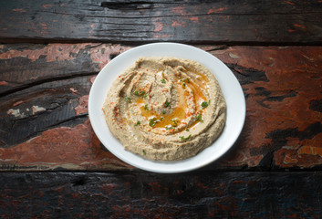 Delicious hummus on rustic wooden kitchen table. This is an Arab and Middle East origin appetizer meal