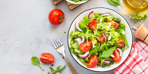 Green salad from fresh leaves and tomatoes.