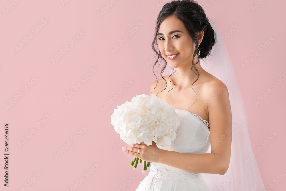 Wall mural Beautiful young Asian bride on color background