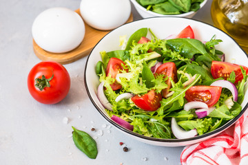 Green salad from fresh leaves and tomatoes.