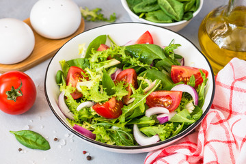 Green salad from fresh leaves and tomatoes.