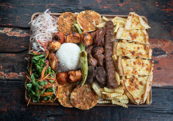 Mixed turkish kebab plate isolated on rustic wooden table