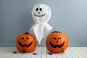 Halloween holiday concept with jack pumpkin and ghost decor on wooden table