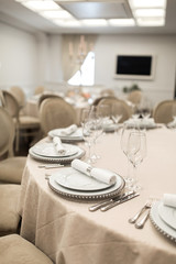 The white round banquet table in the restaurant is decorated with fresh flowers. Stylish event decor
