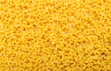Raw yellow cavatappi pasta texture background top view