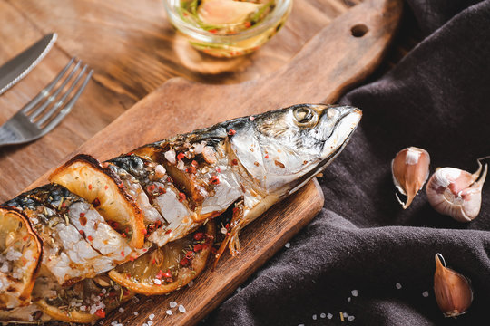Board with prepared mackerel fish on table