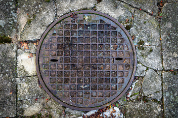 Obraz na płótnie Canvas Cast iron round sewer pit. Rainwater installation in the city.