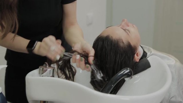 Beautiful young girl wash their hair at the hairdresser.