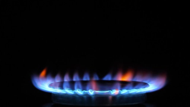 Kitchen burner flaming in the night, closeup. Nobody