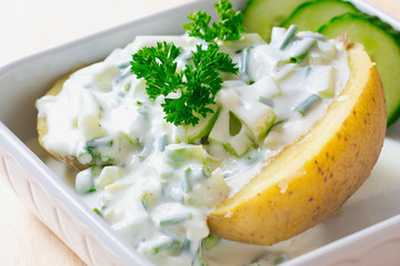 close up of a baked potato with herb curd