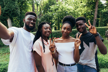 Technology concept. Group of african students taking selfie with phone in campus