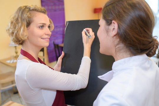 worker writing on the board at the grocery store