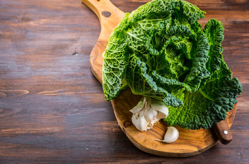 Fresh raw savoy cabbage on wooden background